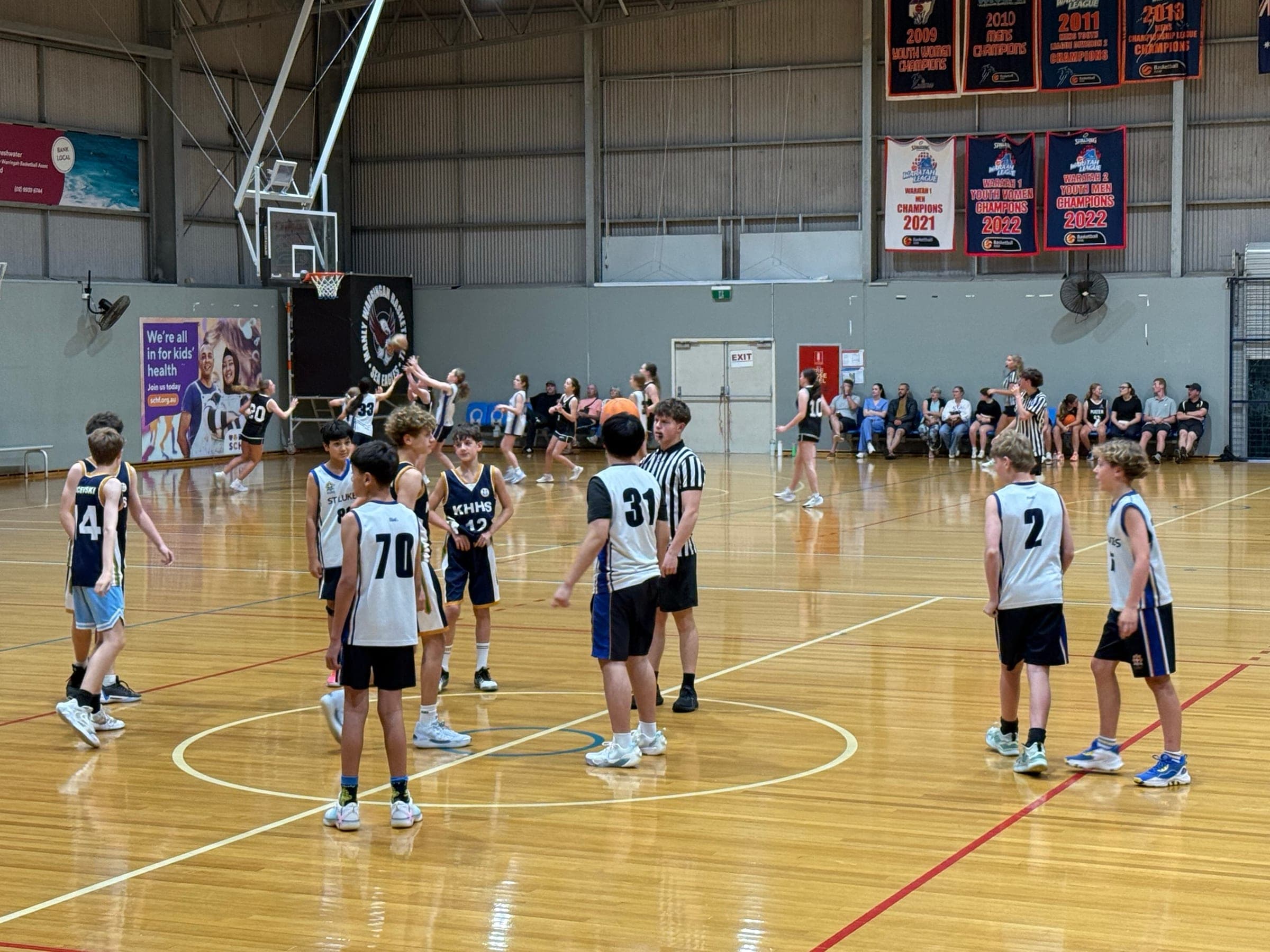 Junior basketball game at tip-off in an indoor stadium